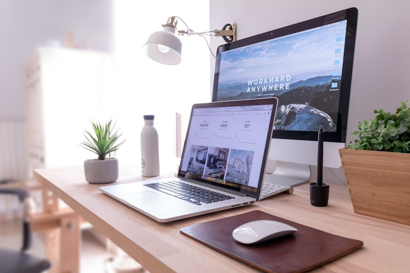 Heller Arbeitsplatz mit Laptop und Bildschirm